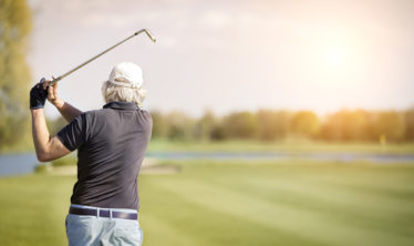 Senior Golfer watches his shot